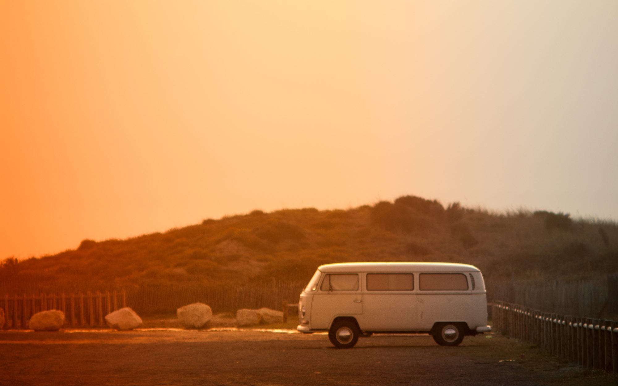 Van garé face à la dune au coucher du soleil